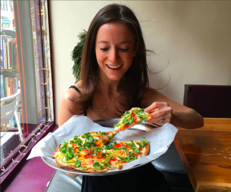 Jackie eating gluten-free pizza at Pie by the Pound