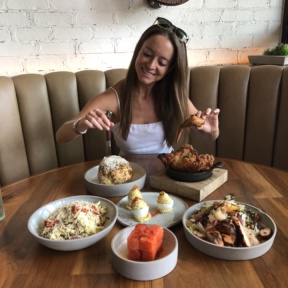 Jackie eating fried chicken and cauliflower at Yardbird