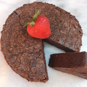 A slice of Flourless Chocolate Cake with strawberries