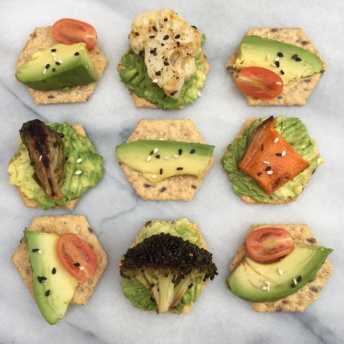 Gluten-free crackers topped with avocado and veggies