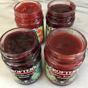 Four jars of fruit spreads by Crofters Organic