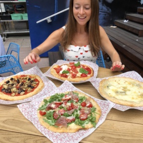 Jackie deciding which pizza to eat first at Ribalta Mo