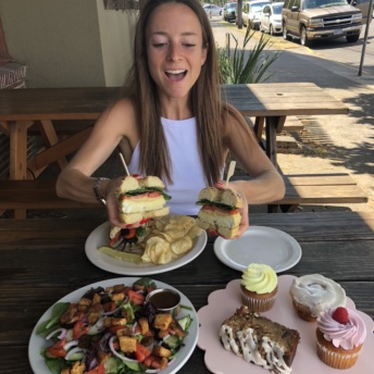 Jackie eating a bagel sandwich at New Cascadia