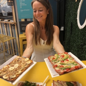 Jackie eating gluten-free pizza from Cheska's