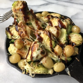 Roasted Brussels Sprouts with Grapes, Cheddar, and Balsamic Glaze in a skillet