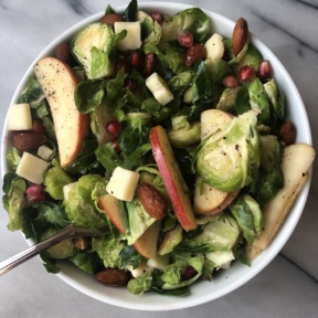 Shredded Brussels Sprouts and Apple Salad with pomegranate seeds, cheddar cheese, almond