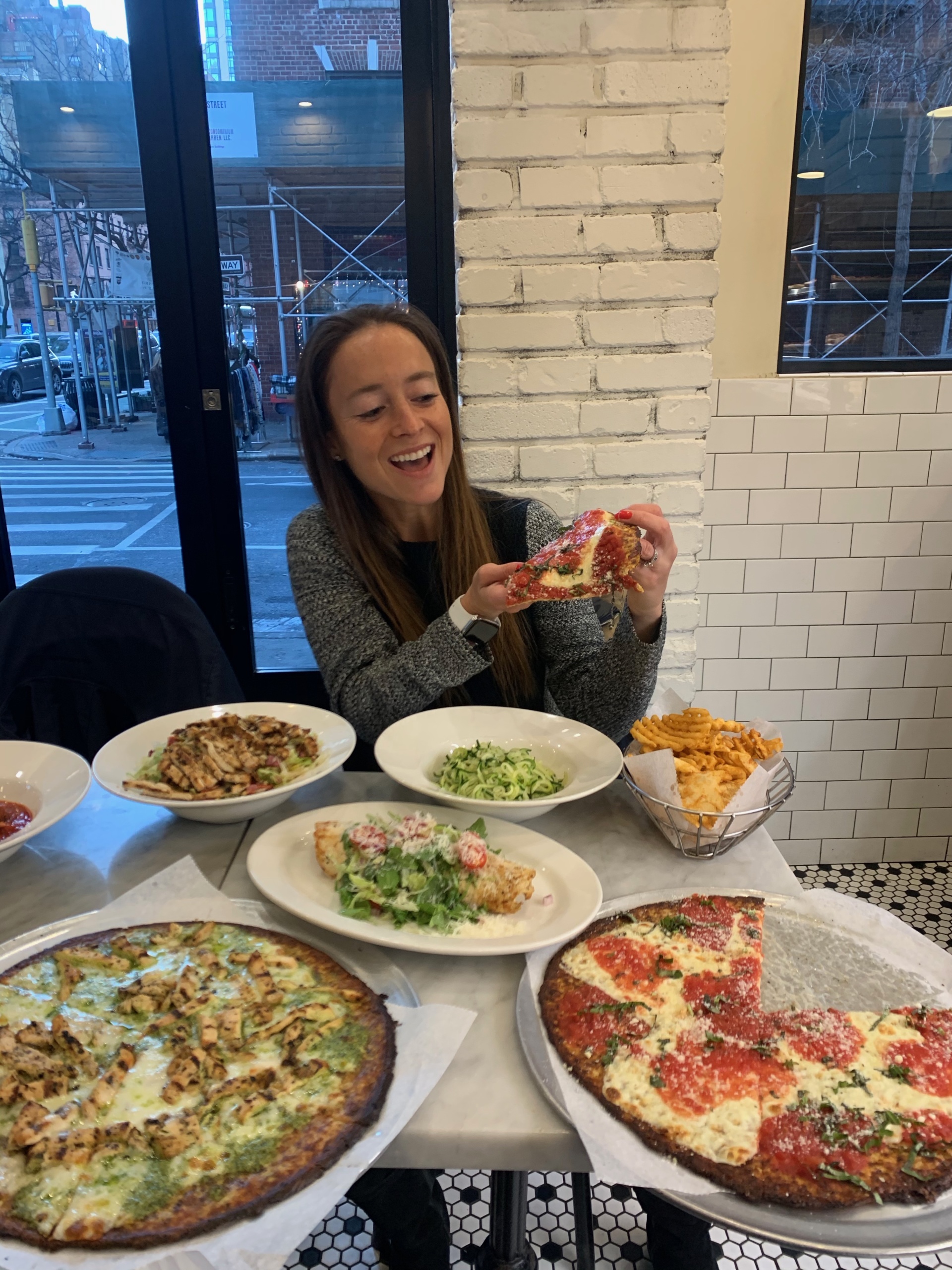 Jackie eating gluten-free cauliflower pizza at Marinara Pizza