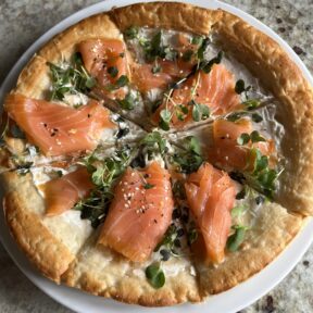 Gluten-free smoked salmon brunch pizza cut into 8 slices