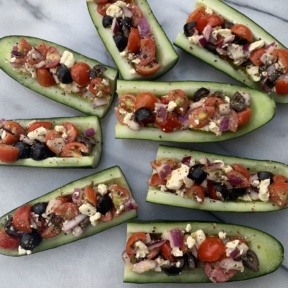 Making Greek Cucumber Boats with tomatoes and olives