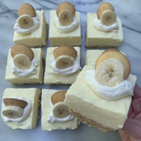 Banana Pudding Cheesecake Bars with whipped topping and banana slices