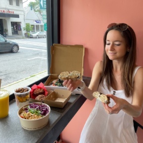 Jackie eating gluten-free bagel at Root2Rise NY