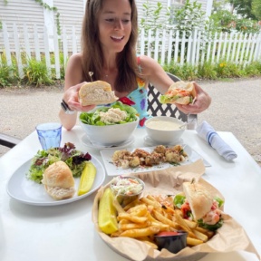 Jackie eating a lobster and crab roll at Brix + Brine