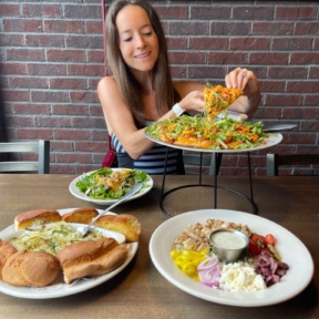 Jackie eating gluten-free pizza from Pizza Luce