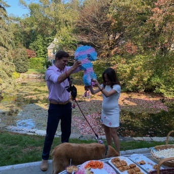 Jackie and Brendan and Odie with gender reveal pinata