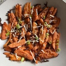 Gluten-free Cheesy Smashed Carrots with parmesan and green onion garnish
